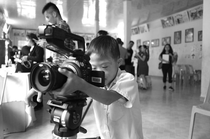 Little girl looking through a large filmming camera